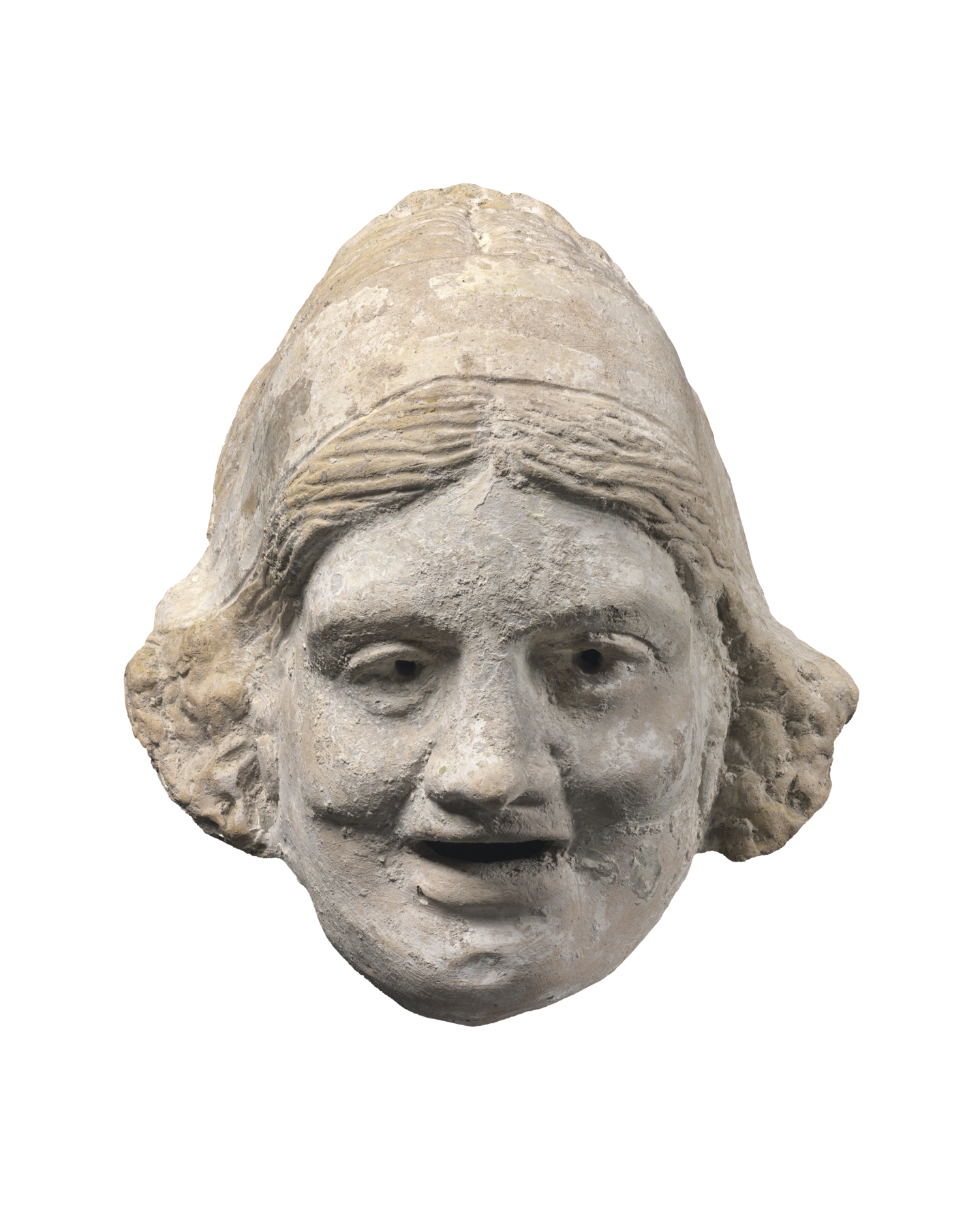 Fotografia. Máscara de pedra representando uma mulher. Tem cabelos curtos, olhos pequenos, bochechas proeminentes e boca entreaberta, levemente sorridente.
