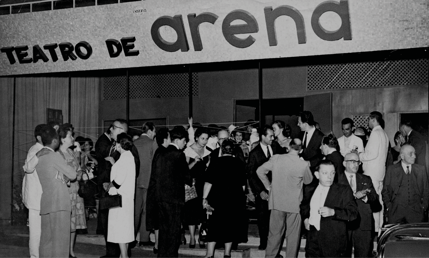 Fotografia em preto e branco. Homens e mulheres reunidos em frente à fachada de um teatro. Na parte superior, o texto: Teatro de Arena.