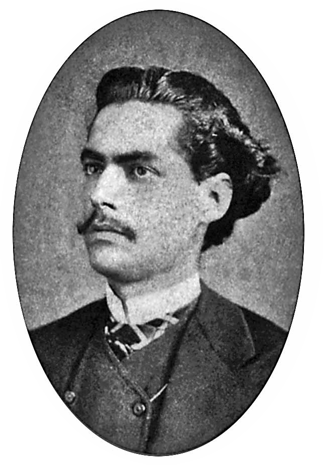 Fotografia em preto e branco. Retrato de homem de cabelo curto ondulado e bigode, vestido com camisa, colete e paletó.