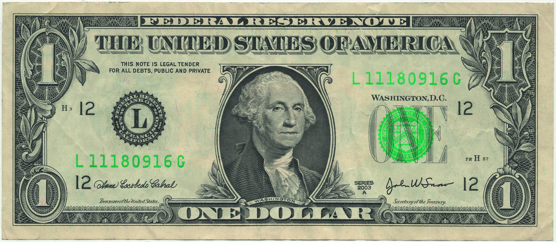 Foto. Nota de um dólar dos Estados Unidos. No centro, imagem de um homem com estilo de penteado e roupas do século XIX. Acima, as informações "Federal Reserve Note" e o número 1 nos quatro cantos da nota.
