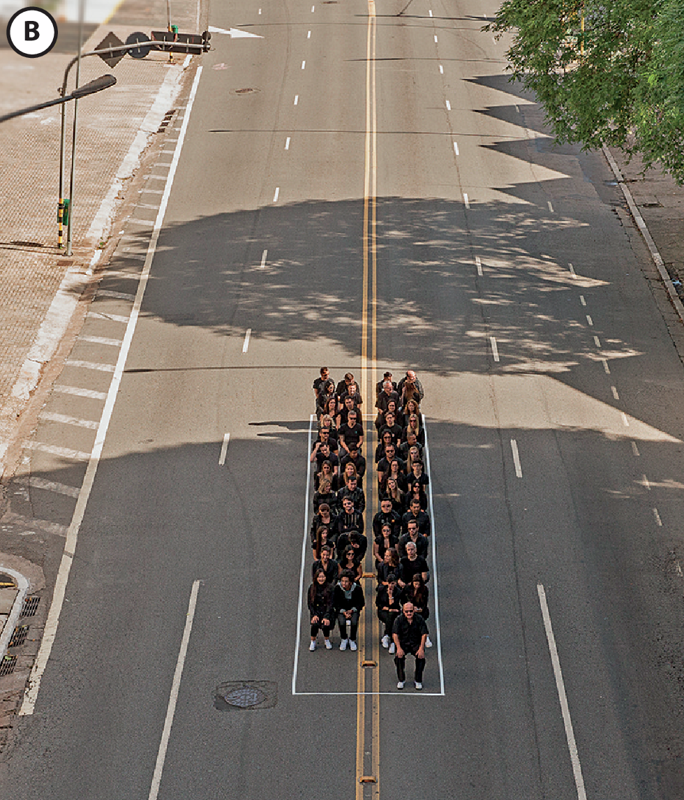 Fotografia B. Pessoas sentadas dentro de um retângulo do tamanho de um ônibus feito na rua.