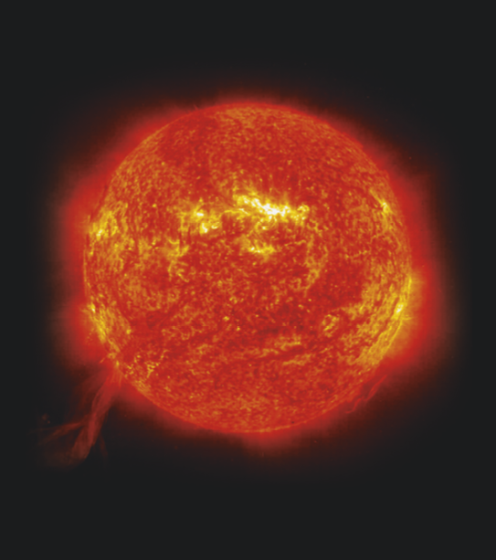 Fotografia que mostra o Sol. Ele tem formato redondo, cor avermelhada com algumas regiões amarelas e camada vermelha difusa ao redor.