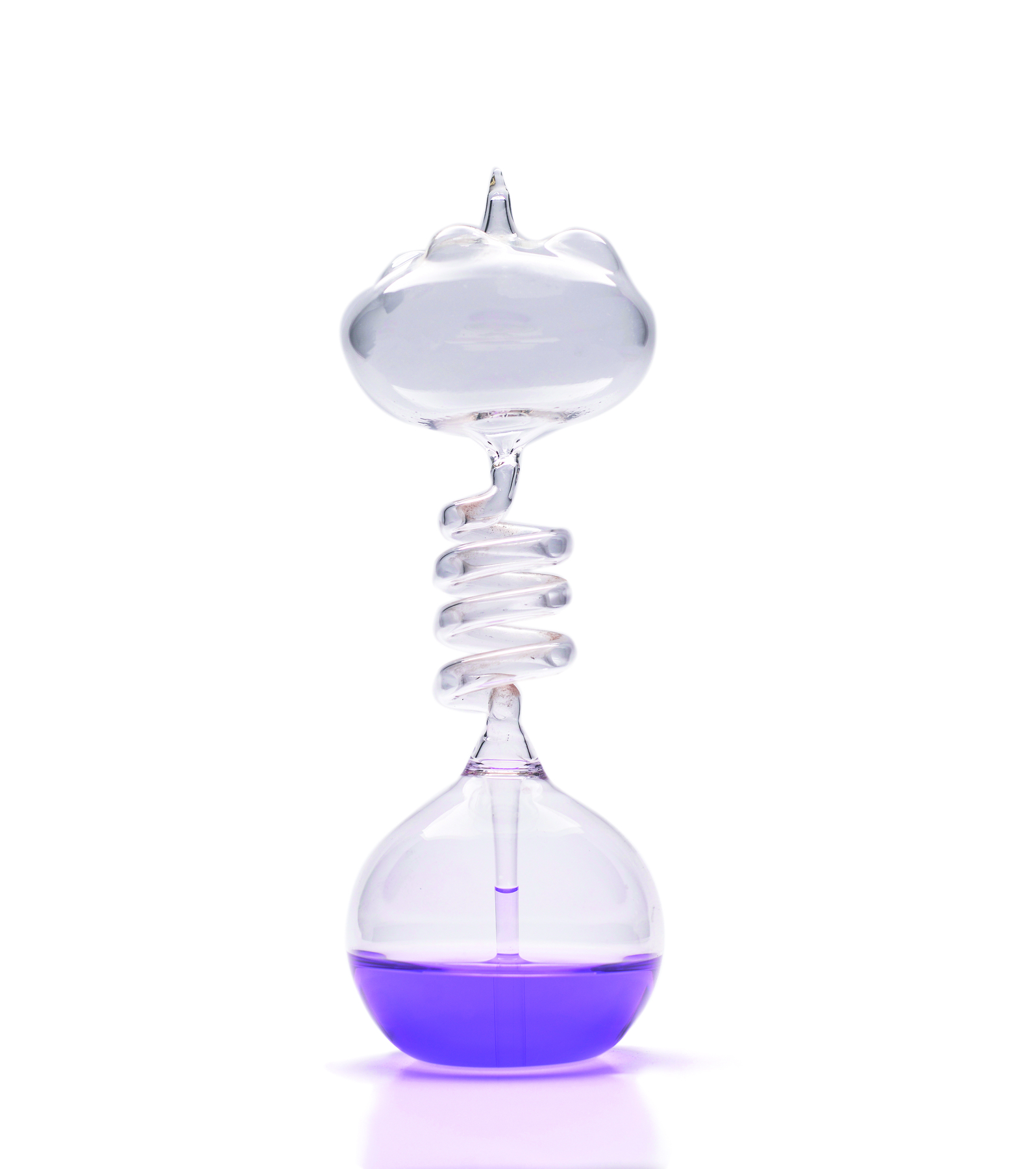 Fotografia de um recipiente de vidro transparente com partes superior e inferir arredondadas e parte do meio em forma de tubo fino espiral. Há um líquido roxo dentro dele, ocupando quase metade da parte inferior.