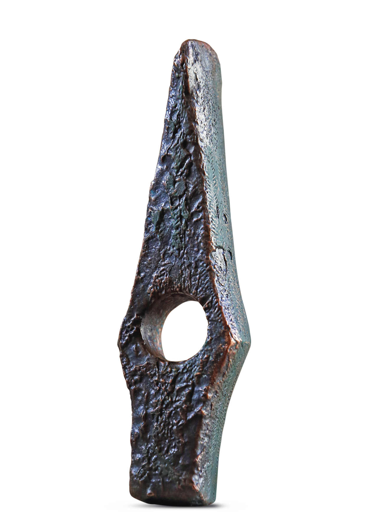 Fotografia, Ponta de machado feita de metal escuro disposta na posição vertical. Com formato de um losango pontiagudo, achatado na base, tem um buraco redondo na parte inferior. Na parte superior, uma ponta fina.