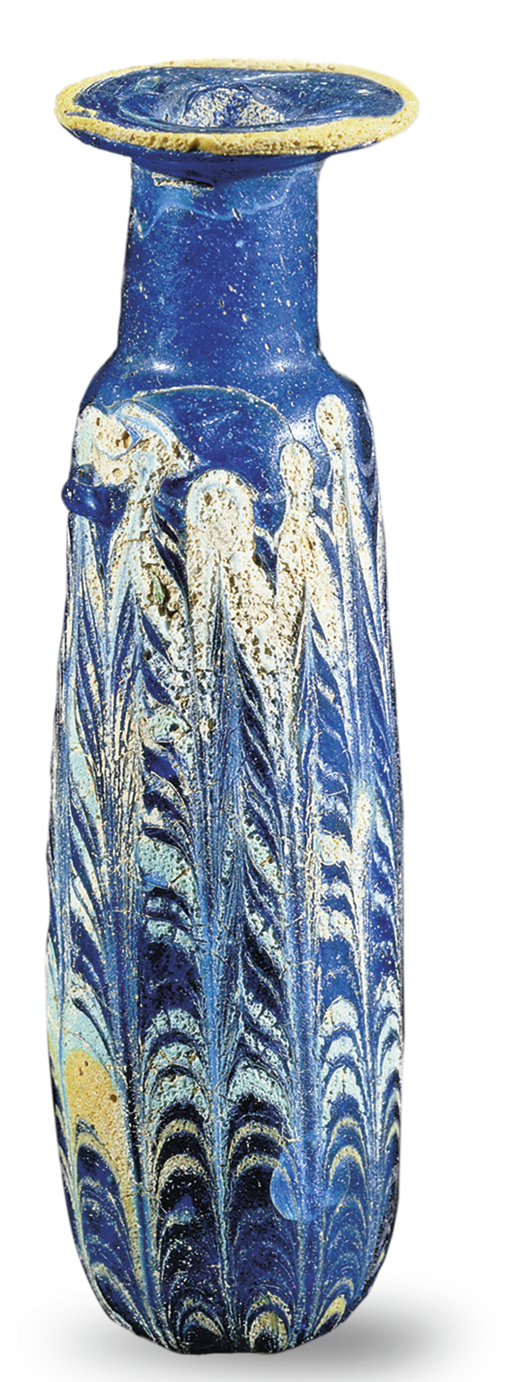 Fotografia. Vaso comprido com formato tubular de cor azul com manchas de cor branca e base arredondada.