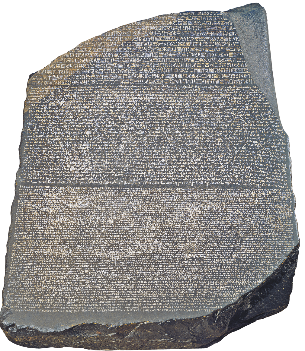 Fotografia. Uma pedra grande de cor cinza, com bordas irregulares. Sobre a pedra, escrituras na horizontal, em linhas, ilegível.