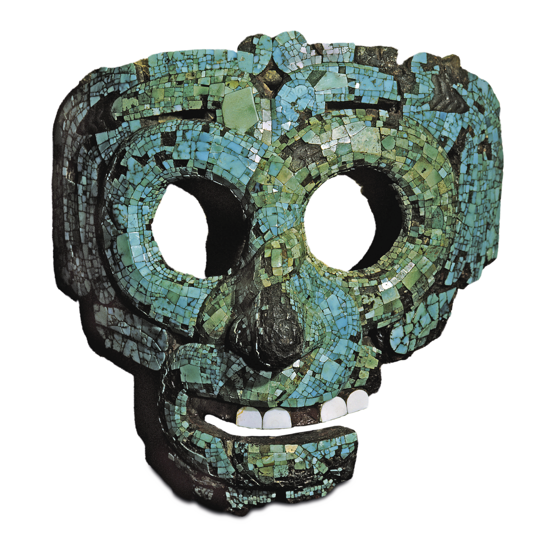 Fotografia. Máscara em feições humanas feita coberta por um mosaico de pedras pequenas em tons de turquesa, com variações desde verde e a azul claro. Dois círculos vazados correspondem ao formato de dois olhos. A boca também é vazada, forma um sorriso leve e têm quatro pequenos dentes brancos.
