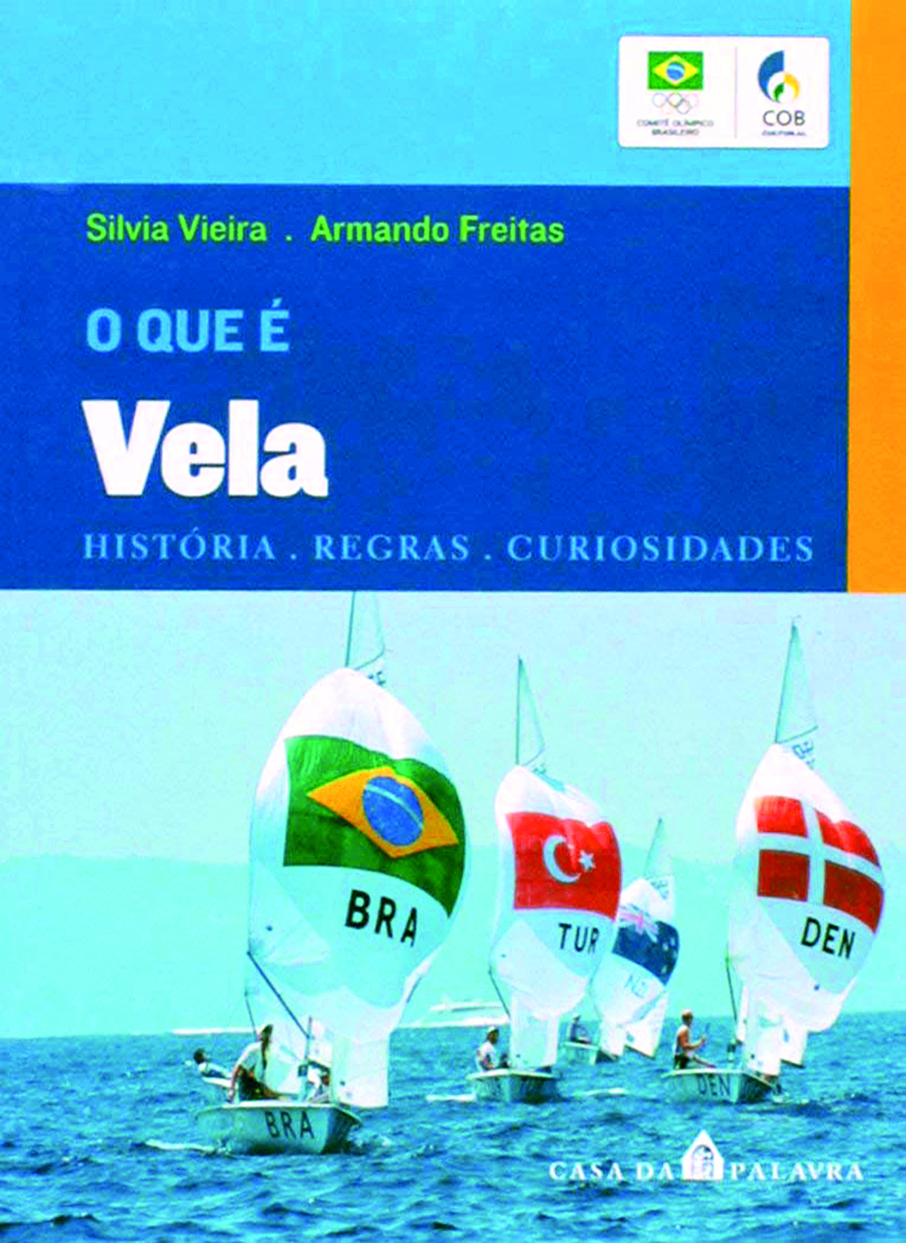 Capa de livro. Fotografia de embarcações a vela com bandeiras de alguns países navegam em águas oceânicas em um dia de céu azul. Na parte superior, sobre um retângulo horizontal azul-escuro, o nome dos autores: Silvia Vieira e Armando Freitas. Logo abaixo, o título do livro: O QUE É VELA.