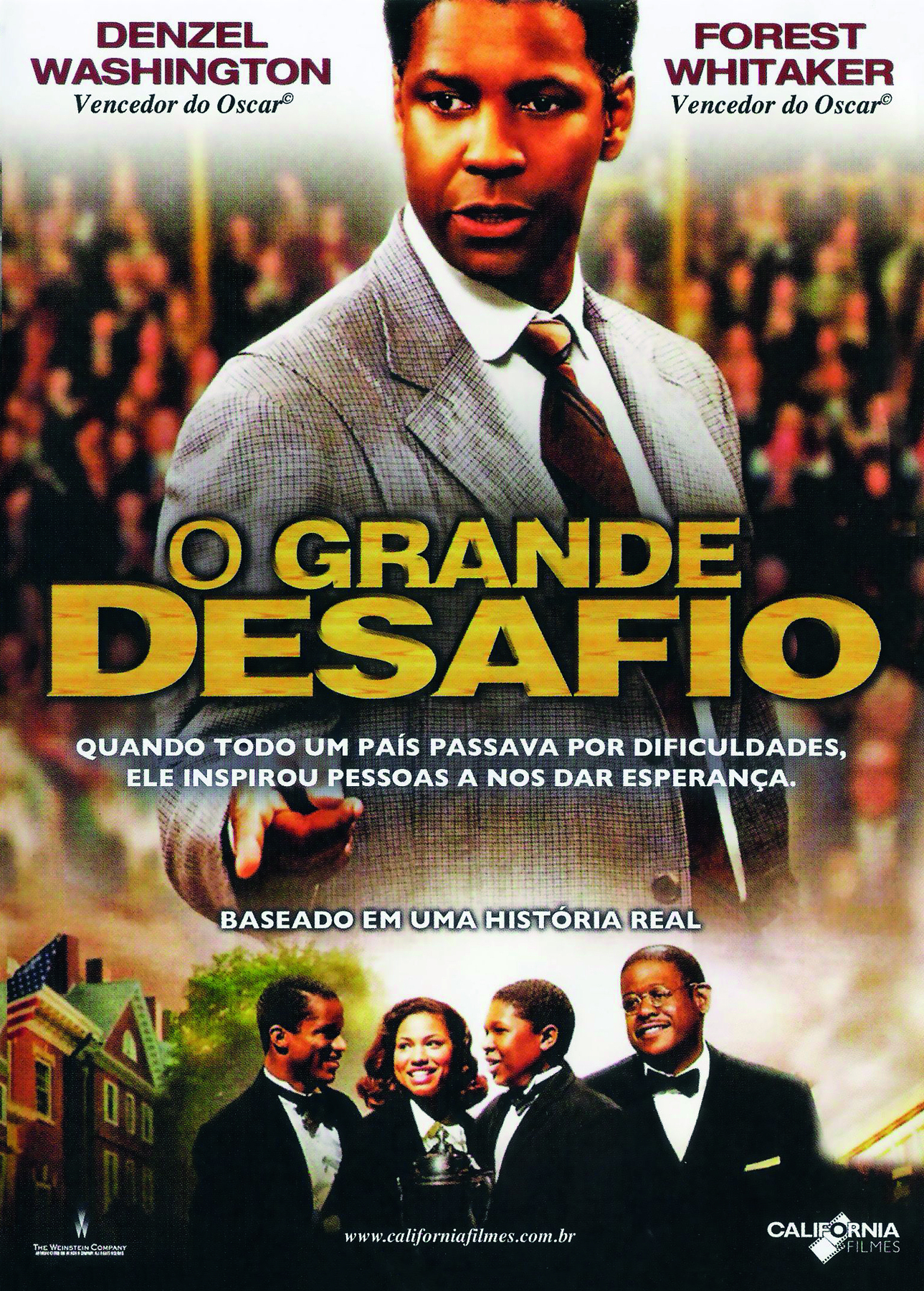 Fotografia. Reprodução de cartaz de filme. Centralizado, o título: 'O GRANDE DESAFIO'. Ao fundo, fotografia de um homem em meio perfil vestindo camisa social branca, paletó cinza e gravata marrom, em pé e de costas para uma plateia. Na parte inferior, três homens e uma mulher, todos de traje a rigor; os homens de terno e gravata borboleta escuros. Todos estão sorrindo.