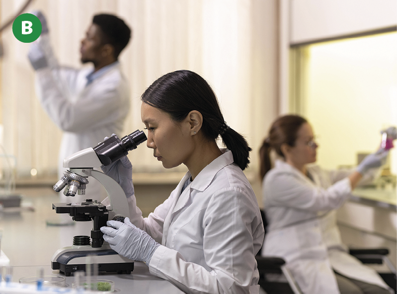 Fotografia. Ambiente de pesquisa científica bem organizado e bem iluminado, onde três pessoas de avental e luvas brancas exercem sua atividade de pesquisa, conduzindo experimentos e fazendo observações em microscópio.