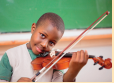 Imagem: Fotografia. Um menino toca um violino. Fim da imagem.