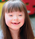 Imagem: Fotografia. Uma menina sorridente de cabelo liso longo e castanho-claro. Fim da imagem.