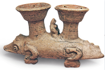 Imagem: Fotografia. Escultura de um vaso em cerâmica que apresenta duas cumbucas paralelas sobre as costas de um animal de corpo comprido e quatro patas curtas. Fim da imagem.