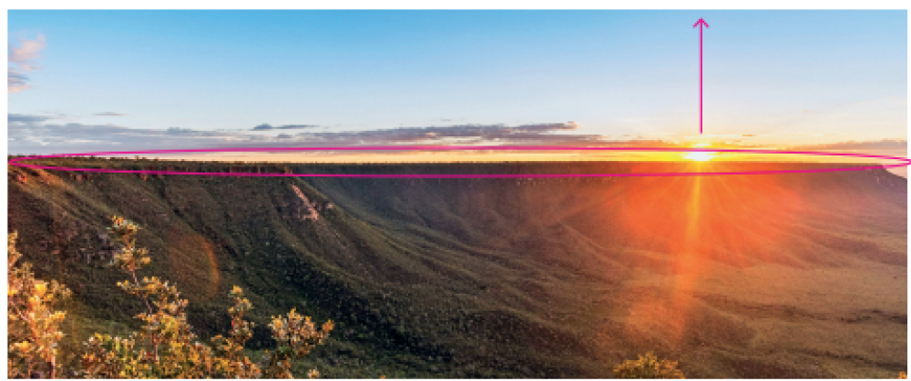 Imagem: Fotografia. Vista geral de local com morros altos com vegetação rasteira em verde. À direita, na parte inferior, debaixo de nuvens cinzas na horizontal, sol redondo em amarelo incandescente. Acima, céu de cor azul-claro. Resposta: Circulo abaixo das nuvens cinzas na horizontal. Fim da imagem.