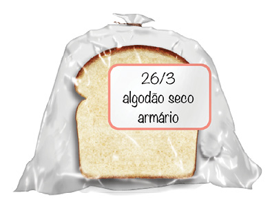 Imagem: Fotografia. Um saco plástico transparente com um pedaço de pão de forma de cor bege, com o contorno superior em marrom. Etiqueta com texto : 26/3 algodão seco armário.  Fim da imagem.