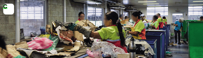 Imagem: Fotografia C. Sobre mesas, dejetos em plástico e papel e de frente, pessoas separando com luvas nas mãos. Elas usam uniforme composto por camiseta de mangas curtas em amarelo e parte inferior em laranja. À frente, mulher de cabelos longos escuros amarrados para trás.  Fim da imagem.