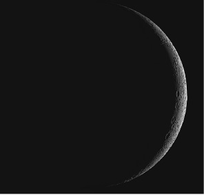 Imagem: Fotografia. Sombra grande sobre lua, com a ponta da direita, forma fina vertical de cor cinza-claro.  Fim da imagem.