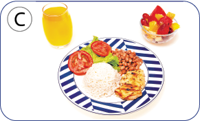 Imagem: Fotografia C. Mesmo tipo de prato com arroz, salada, tomates vermelhos, grãos de feijão e frango. À esquerda, copo transparente com suco de laranja e à direita, utensílio redondo transparente com salada de fruta.  Fim da imagem.