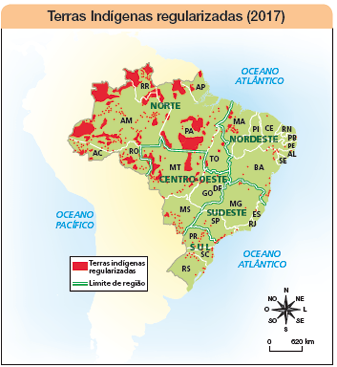 Imagem: Ilustração. Mapa. Terras Indígenas regularizadas (2017). Rosa dos ventos em preto: N, NO, O, SO, SE, L, NE.  Escala: 0 – 620 Km Vermelho: Terras indígenas regularizadas Verde: Limite de região Limite de região entre MT e RO, AM, PA e TO.  Limite de região entre MA E PA e TO. BA e TO, GO, ME e ES.  Limite de região entre MG e BA, GO, MS e PR.  Mais à esquerda, Oceano Pacífico. À direita: Oceano Atlântico.  Fim da imagem.