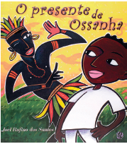 Imagem: Fotografia. Capa de livro. Fundo em laranja e cinza, com silhueta de pássaros de cor laranja. Na parte inferior, grama de cor verde, com duas pessoas à frente. Um homem de pele negra, coroa com plumas coloridas, duas argolas douradas nas orelhas, com colar de cor laranja e saiote com plumas coloridas em amarelo, laranja e verde, com o olho esquerdo fechado e o olho direito aberto, com o corpo para diagonal, com a mão esquerda para baixo e outra mão direita para cima. Mais à direita, um menino negro de cabelos pretos, com camiseta e calça branca, com as mãos, olhando para à esquerda, com lábios de cor rosa. No alto, céu de cor amarela com detalhes em laranja. Na parte superior, título do livro.  Fim da imagem.