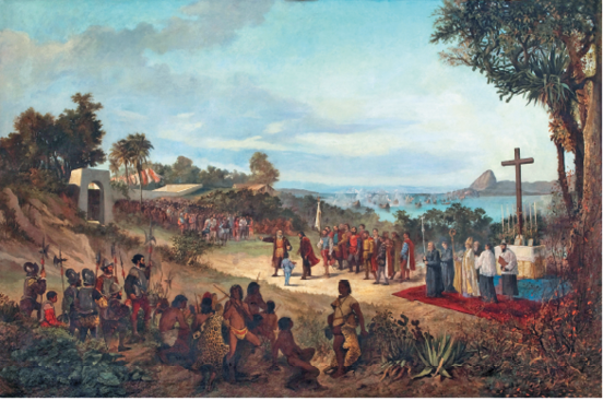 Imagem: Pintura. Vista geral de local com solo de cor marrom-claro. À esquerda, local com vegetação verde, dezenas de homens morenos, alguns com pele de animal no corpo. Na ponta da esquerda, homens com roupa de soldados com capacete, colete cinza, com lança fina à esquerda. Mais ao fundo, caminho por onde há um senhor de cabelos grisalhos, roupa em marrom-claro e casaco em marrom-escuro, apontando para à esquerda. Ao lado, homem de pele clara, cabelos escuros, capa vermelha e calça escura, uma criança vista de costas de casaco azul. Mais à direita, um púlpito com uma grande cruz marrom e perto, homens com roupas religiosas em branco e outros em cinza. Perto deles, homens em pé, aglomerados. Em segundo plano, árvores de folhas verdes. Em terceiro plano, mar de água azul-claro e morros. No alto, céu azul-claro com nuvens brancas à esquerda.  Fim da imagem.