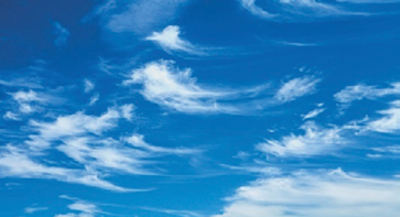 Imagem: Fotografia. Nuvens brancas com formato de pinceladas no céu azul.  Fim da imagem.
