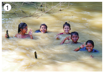 Imagem: Fotografia 1. Cinco crianças estão sorrindo e dentro de um rio.  Fim da imagem.