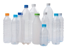 Imagem: Fotografia. Várias garrafas de plástico vazias com tampas coloridas.    Fim da imagem.