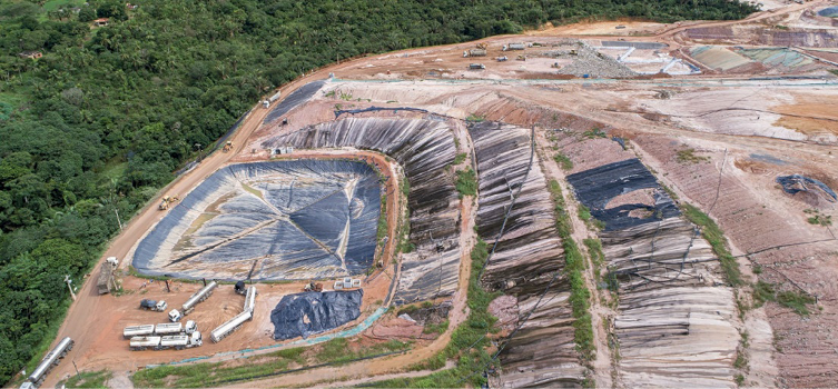 Imagem: Fotografia. Vista aérea de um terreno em camadas. Ao lado há uma floresta. Fim da imagem.