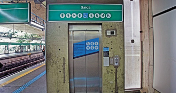 Imagem: Fotografia. Um elevador na estação de metrô com placas de pessoas preferenciais.   Fim da imagem.