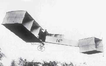 Imagem: Fotografia em preto e branco. Avião com asas retangulares, cauda comprida e um quadrado na base.   Fim da imagem.