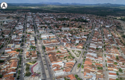 Imagem: Fotografia. A: Vista aérea de cidade extensa com casas de alvenaria com pouca vegetação entre elas.  Fim da imagem.