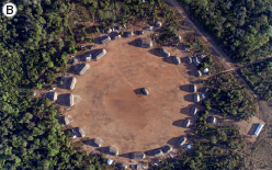 Imagem: Fotografia. B: Vista aérea de aldeia formada por um campo aberto de terra com ocas ao redor. Ao redor das ocas há vegetação densa de floresta. Fim da imagem.