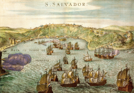 Imagem: Ilustração. Vista de muitos navios sobre o mar chegando em terra formada por morros com porto abaixo e cidade no topo. Fim da imagem.