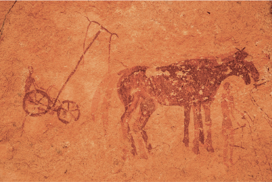 Imagem: Fotografia. Rocha com pinturas de homem sobre uma carroça puxada pela sombra de um cavalo.   Fim da imagem.