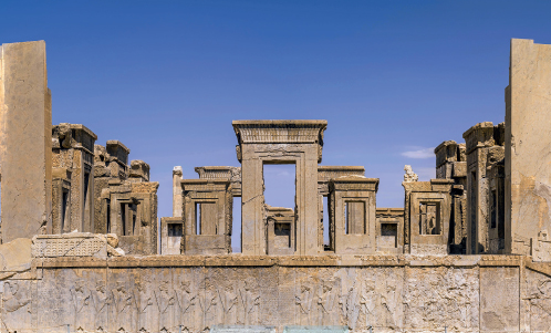 Imagem: Fotografia. Ruínas de palácio apenas com arcos retangulares de passagens diversas. Nas partes superioras dos arcos há arabescos.   Fim da imagem.