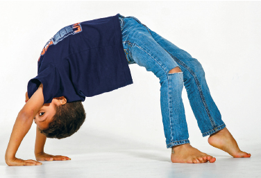 Imagem: Fotografia. Uma criança, de camisa e calça azul, está com o corpo curvado para trás e as mãos no chão. Fim da imagem.