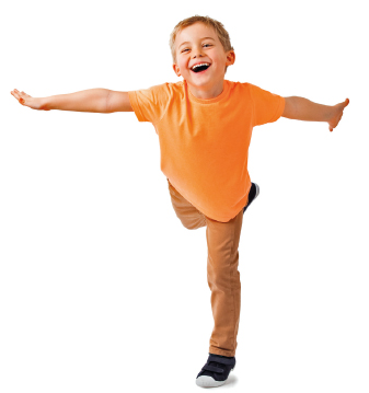 Imagem: Fotografia. Uma criança, com camisa laranja e calça bege, está com a perna direita levantada para trás. Os dois braços estão abertos na lateral do corpo.  Fim da imagem.