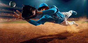 Imagem: Fotografia. Uma pessoa, usando chapéu azul e uma luva na mão esquerda, está com os braços esticados na direção de uma bola branca. O chão é de terra.   Fim da imagem.