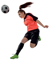 Imagem: Fotografia. Uma mulher está com os braços estendidos ao lado do corpo e o pescoço inclinado para frente na direção de uma bola de futebol.  Fim da imagem.
