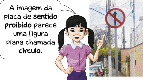 Imagem: Ilustração. Uma menina com cabelo comprido e preso e camiseta rosa está com a mão direita na cintura e o dedo indicador esquerdo levantado. Ela fala: A imagem da placa de sentido proibido parece uma figura plana chamada círculo. Ao seu lado, foto de uma placa circular com borda vermelha. No centro há uma seta apontado para cima com uma reta diagonal no meio.  Fim da imagem.