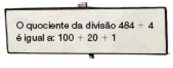 Imagem: Ilustração. Placa com a informação: O quociente da divisão 484 ÷ 4 é igual a: 100 + 20 + 1.   Fim da imagem.