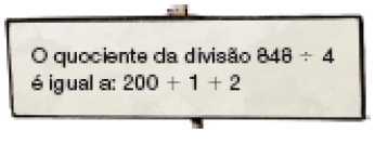 Imagem: Ilustração. Placa com a informação: O quociente da divisão 848 ÷ 4 é igual a: 200 + 1 + 2.  Fim da imagem.