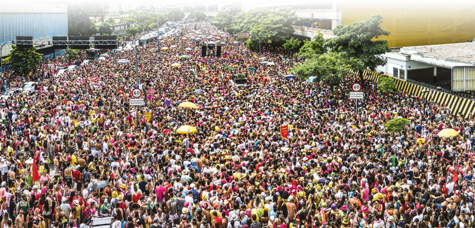 Fotografia. Uma multidão ocupando uma extensa avenida.