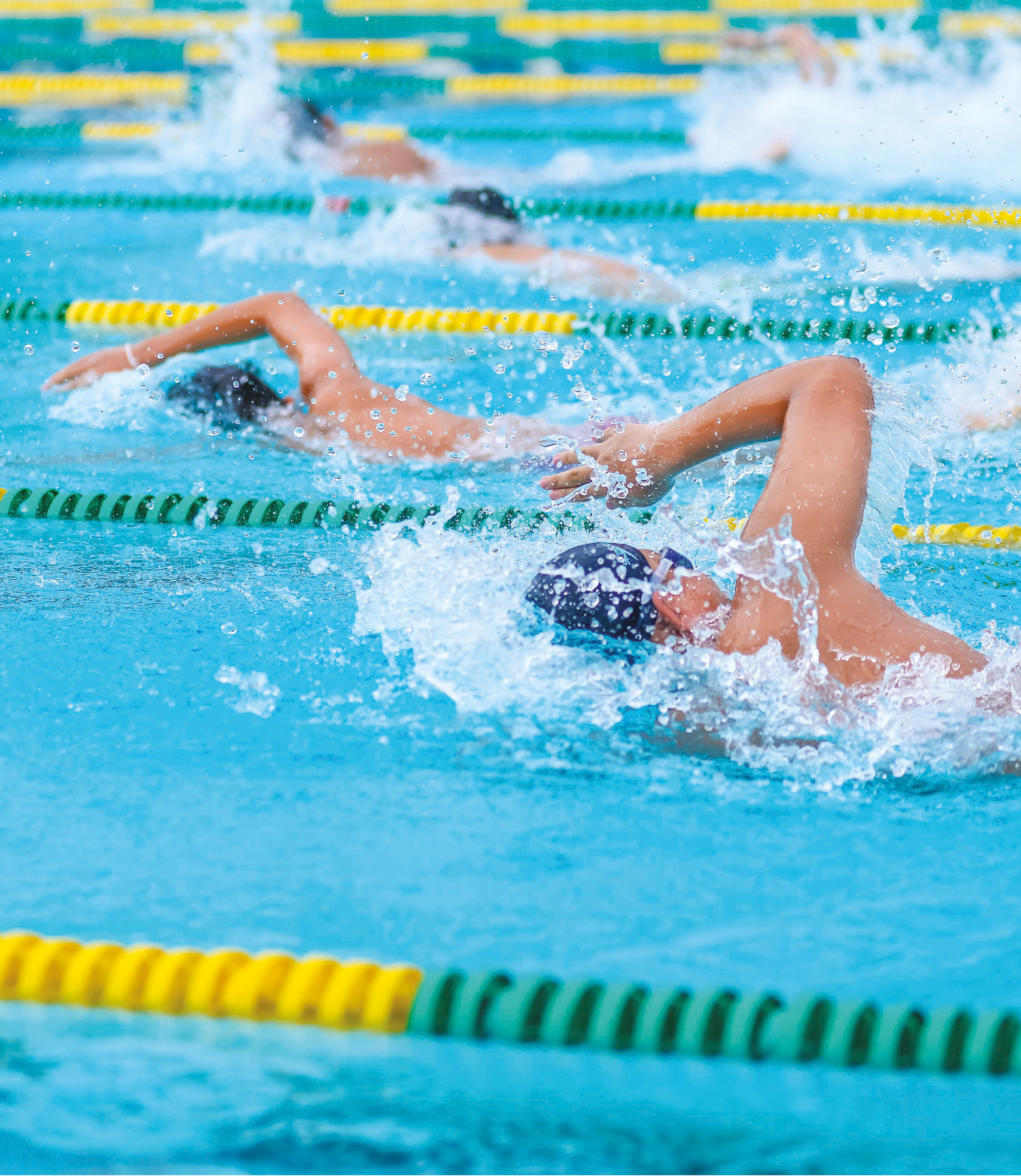 Fotografia. Nadadores de touca e óculos em uma piscina, cada um em uma raia.