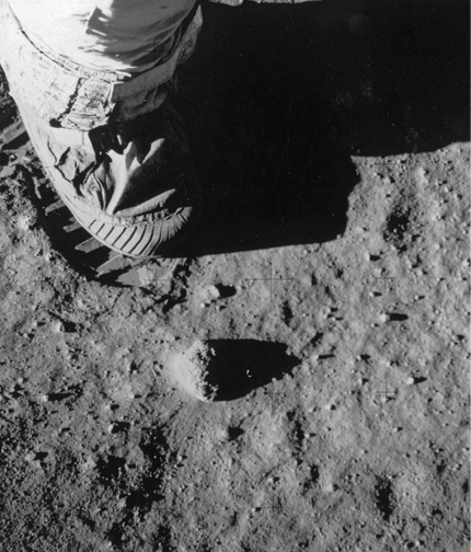 Fotografia. Pé de um astronauta na superfície da Lua, deixando uma pegada.