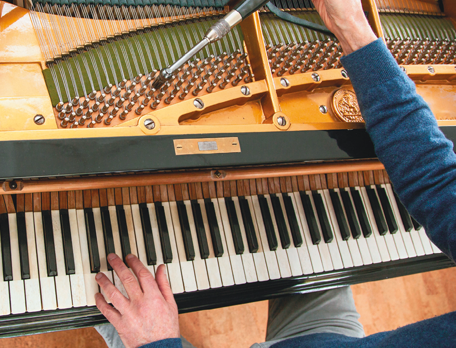 Fotografia. Destaque para as mãos de uma pessoa tocando um piano.