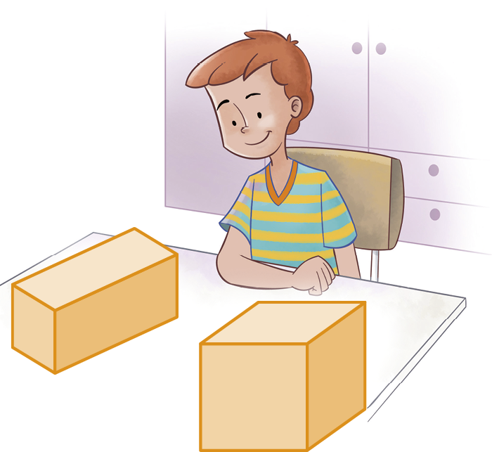 Ilustração. Menino branco de cabelo castanho e blusa listrada em azul e amarelo está sentado em uma cadeira e apoia o braço direito na mesa. O menino observa um bloco retangular e um cubo. Ao fundo, armários.