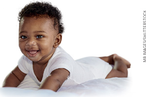 IMAGEM: um bebê engatinha e sorri. FIM DA IMAGEM.