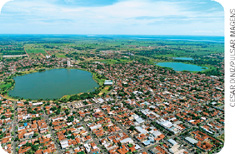 IMAGEM: fotografia aérea da cidade de três lagoas. entre as casas e edifícios, há três grandes lagoas. FIM DA IMAGEM.